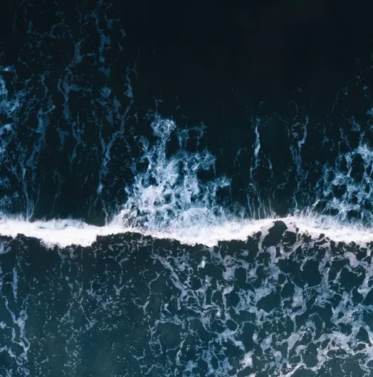 Aerial view of ocean waves and foam.