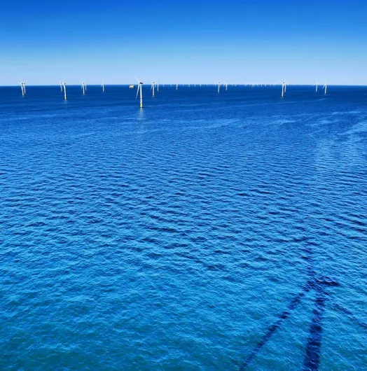 Offshore wind turbines in deep blue water.