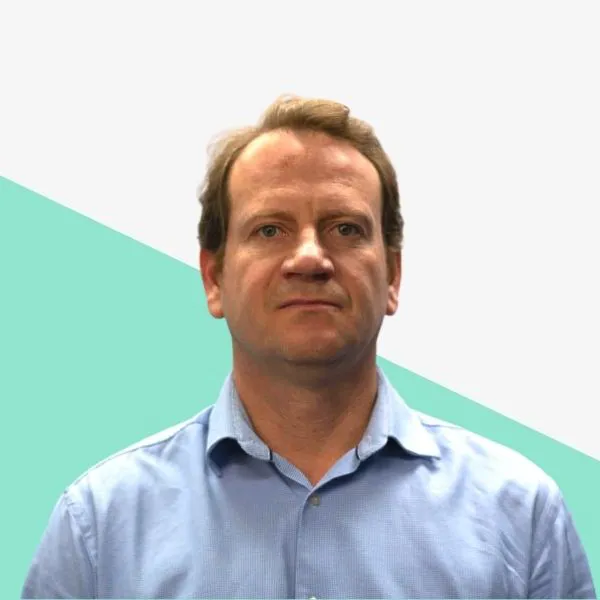Man in a blue shirt against a geometric background.