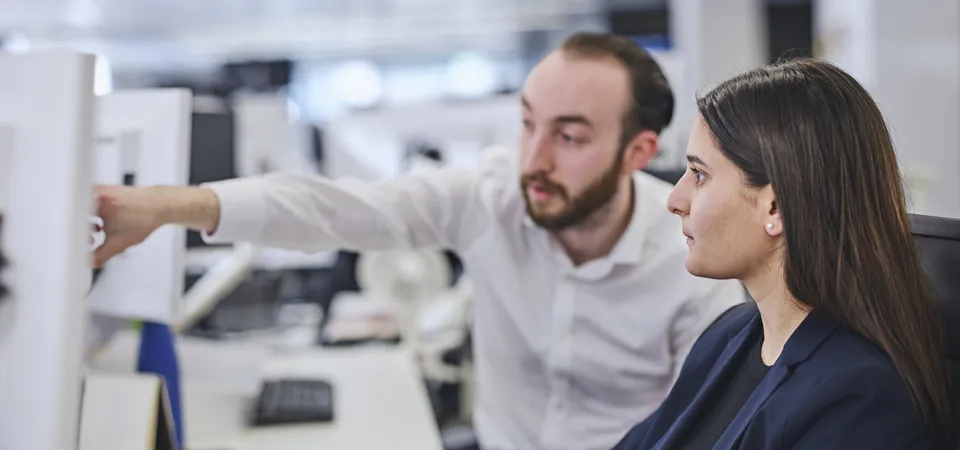 Two colleagues working together at a computer.