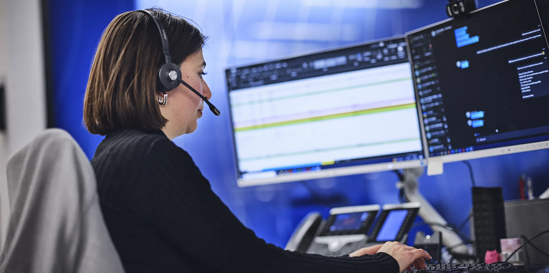 Clarksons employee with a headset on at computer